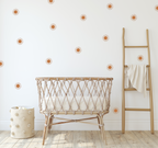 boho nursery with terracotta sun stickers and a canopy over a baby bassinet