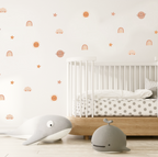 cosmic cuties wall stickers arranged above a baby crib in a neutral nursery