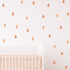 Blush Forest wall decals in blush tones shown above a crib in a minimal kids room decor
