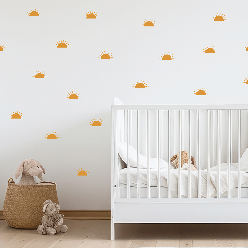 Golden sunrise wall decals scattered across a nursery wall above a white crib and soft toys
