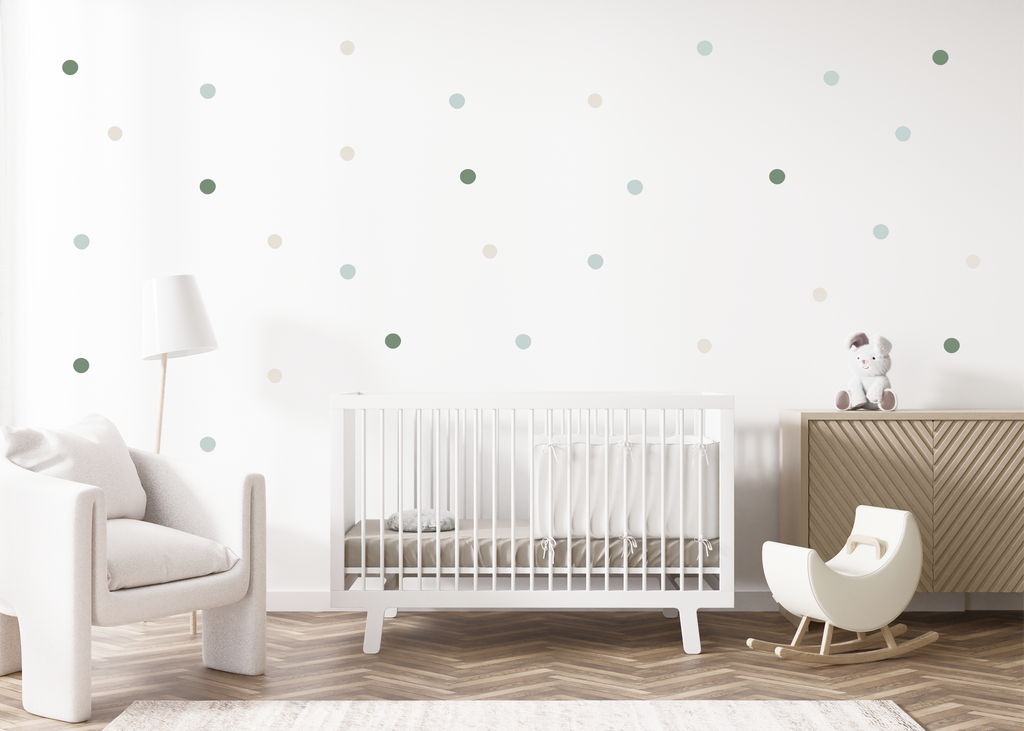 Pastel green and beige dot decals arranged on a clean nursery wall above a crib and wooden cabinet