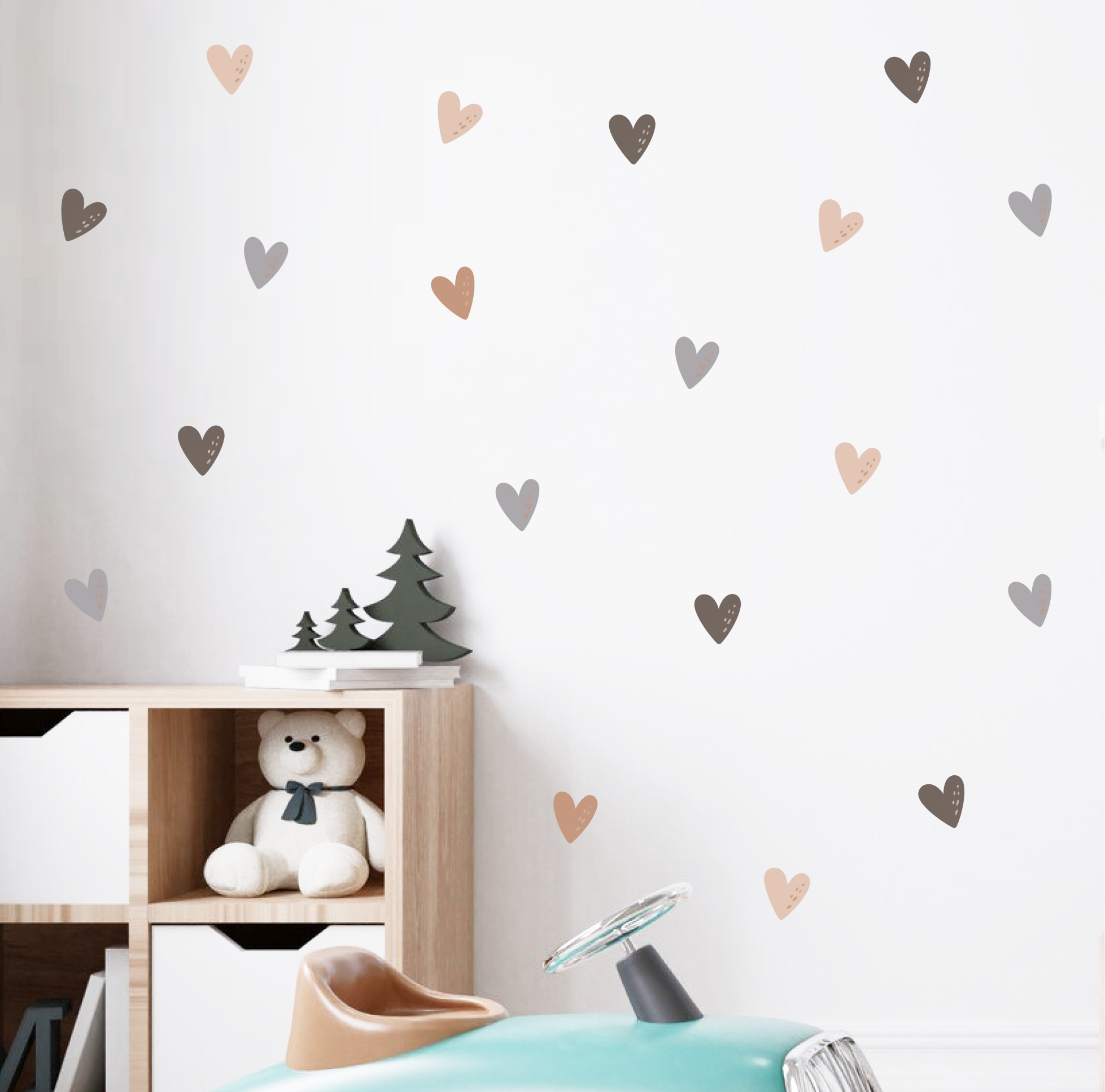 Neutral and pastel heart wall decals decorating a kids’ room behind a crib and toy car