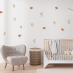 Mixed wild leaf wall decals in earthy tones styled above a crib in a calm, modern nursery