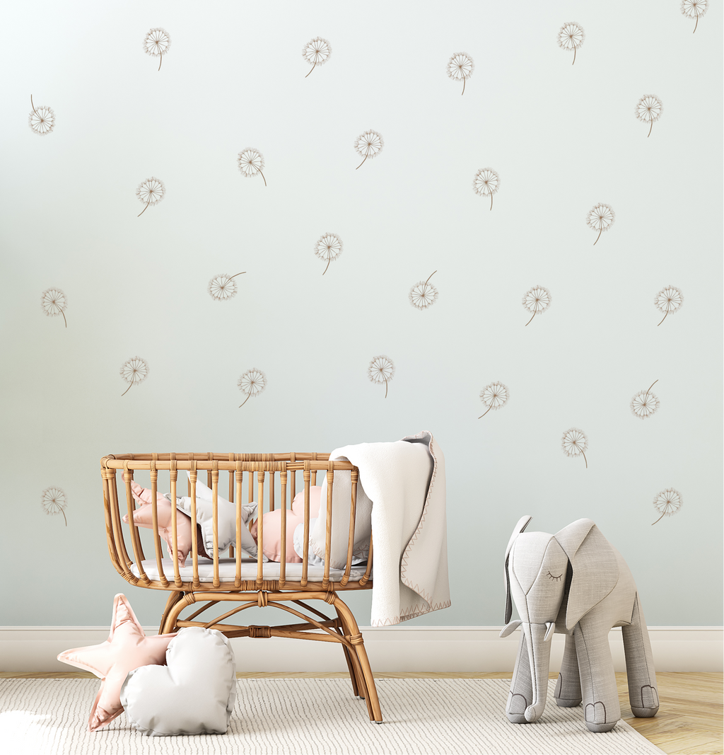 Boho nursery with rattan crib and dandelion wall decals in soft neutral tones